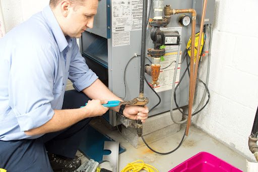 An HVAC technician working on a furnace in Dallas